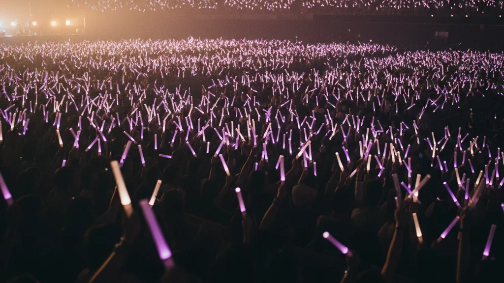 aespa world tour 2026 — purple lightsticks glowing above a faceless concert arena crowd — KoreaHacks